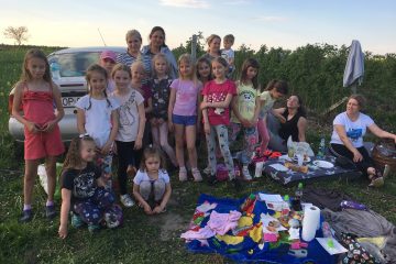 dzieci i dorośli na polanie podczas pikniku