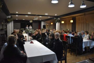 zdjęcie przedstawia salę Kawiarni, stoły,przy których siedzą ludzie