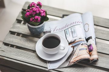 grafika przedstawia filiżankę kawy, różowy kwiat w doniczce, czasopismo