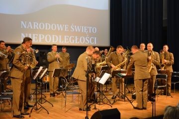 zdjęcie przedstawia wojskową orkiestrę, mężczyzn ubranych w mundury, instruemnty muzyczne